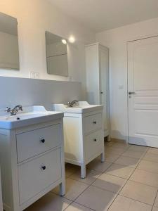 Baño blanco con 2 lavabos y espejo en Villa les Agapanthes en Carantec