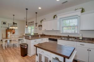 a kitchen with white cabinets and a wooden floor at Our Corner Cottage in Aiken