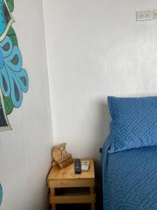 een slaapkamer met een blauw bed en een houten nachtkastje bij Suite frente al mar - CIELO in Montañita