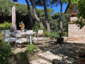 a table with chairs and an umbrella in a yard at Villa orchidea in Rosolina Mare