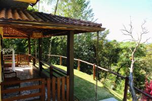 una terraza de madera de una casa con una valla en Chalés de Analuz en Visconde De Maua