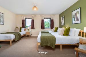 2 camas en una habitación con paredes verdes en NEW Greydawn House - Stunning 4 Bedroom House in Stoke-on-Trent en Stoke on Trent