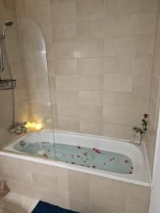 a bathroom with a tub with flowers in it at Luxury Modern Apartment Stay in Sheffield