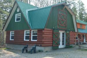 a log cabin with a bench in front of it at Le saint-Achillée in Chateau Richer