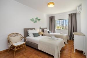 een hotelkamer met 2 bedden en een stoel bij Vilamoura - Cozy and Quiet Holiday Apartment in Vilamoura