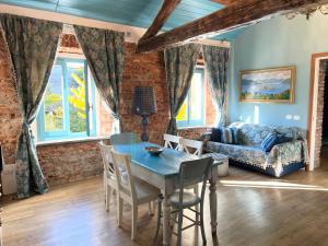 ein Wohnzimmer mit Tisch, Stühlen und Sofa in der Unterkunft Il Giardino Segreto Arona, Charming Apartments in Arona