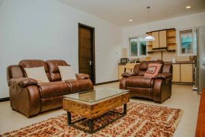 a living room with two leather couches and a coffee table at Jwapano housing in Dar es Salaam