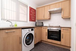 a kitchen with a washing machine and a sink at Central Liverpool Gem 3 bedroom House Private Parking in Liverpool