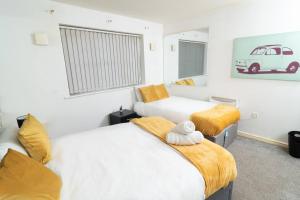 a bedroom with two beds and a picture of a car on the wall at Central Liverpool Gem 3 bedroom House Private Parking in Liverpool