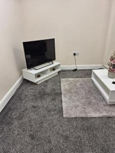 a living room with a flat screen tv on a stand at Hidden Gem - Cosy & Convenient in Kent