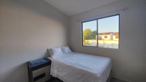 Un dormitorio pequeño con una cama y una ventana. en Casa en Residencial San Andrés, en San Miguel