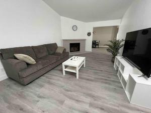 Entire Modern House with King bed & 65inTV في Carmichael: غرفة معيشة مع أريكة ومدفأة