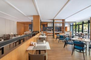 Fairfield by Marriott Zhuji في زويي: مطعم بطاولات وكراسي ونوافذ