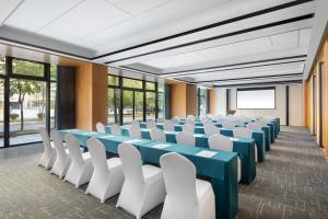 uma sala de conferências com mesas azuis e cadeiras brancas em Fairfield by Marriott Zhuji em Zhuji