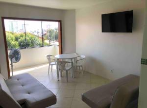 a living room with a table and chairs and a window at Pousada do centro Tramandaí Ap 3 in Tramandaí