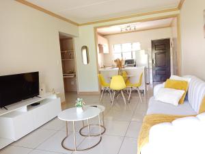 a living room with a couch and a tv at La casa de Miah in Sandton