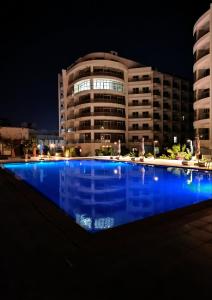 a large swimming pool in front of a building at night at Scandic Resort Apartment B 608 Hurghada in Hurghada