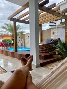 een man zonder shirt die op een terras naast een zwembad ligt bij Casa com piscina in Bombinhas