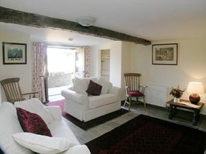 uma sala de estar com um sofá branco e cadeiras em Mouse Castle Barn em Hay-on-Wye