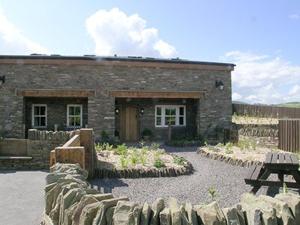 un edificio de piedra con una mesa de picnic delante de él en Mouse Castle Barn, en Hay-on-Wye