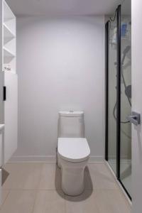 a white bathroom with a toilet and a shower at Furnished Studio with balcony - Downtown #311784 in Montreal