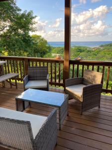 una terraza con sillas y mesas y vistas al océano. en Apartment Diamond Hill Resort en Diamond Rock
