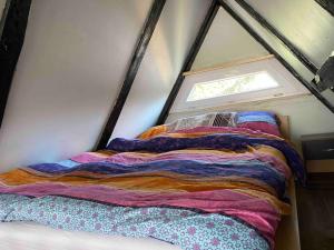 Bett in einem kleinen Zimmer mit Fenster in der Unterkunft Finnhütte Oase in Berlin