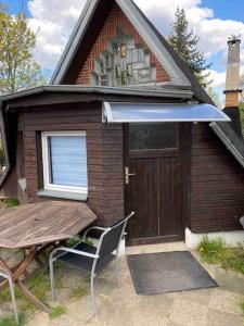 ein kleines Haus mit einem Tisch und einer Holztür in der Unterkunft Finnhütte Oase in Berlin