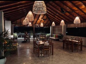 a restaurant with wooden tables and chairs and chandeliers at Sayura House in Colombo