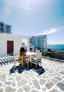 une femme assise à une table sur un balcon dans l'établissement Sayura House, à Colombo