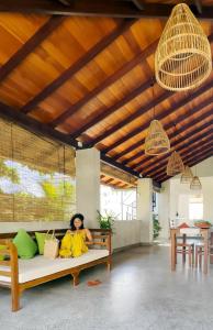 a woman sitting on a couch in a living room at Sayura House in Colombo