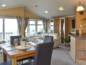 a dining room and living room with a table and chairs at Sunset Lodge in Llanddulas