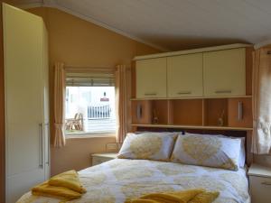 a bedroom with a bed and a window at Sunset Lodge in Llanddulas