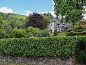 an old house with a hedge in front of it at Creag-ard House in Aberfoyle