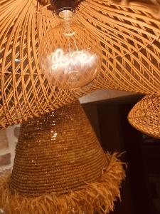 a light hanging from a wicker ceiling at Suite Deluxe & Spa #Wabi-Sabi# in Bray-Dunes