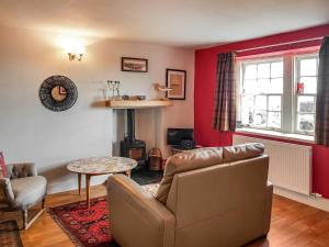 a living room with a couch and a table at Maines Farm Cottage in Chirnside