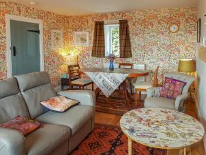 sala de estar con sofá y mesa en Maines Farm Cottage, en Chirnside