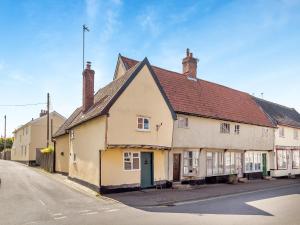 a white building with a red roof on a street at Cottage Ixworth in Ixworth