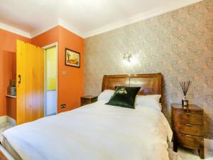 um quarto com uma grande cama branca e paredes cor-de-laranja em Chapel View em Haworth