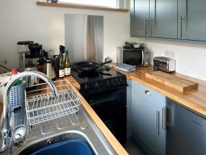 a kitchen with a dish drying rack on the sink at Elmrise Park in Llangain