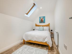 een slaapkamer met witte muren en een bed met een houten hoofdeinde bij Salix 4 - Uk46116 in Wigginton