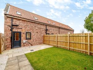 a brick house with a wooden fence and a yard at Salix 4 - Uk46116 in Wigginton
