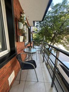 - un balcon avec une table et des chaises dans un bâtiment dans l'établissement Departamento céntrico en Bariloche, à San Carlos de Bariloche