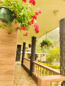 a balcony with flowers hanging from the ceiling at Casas vacacionales Baños in Baños