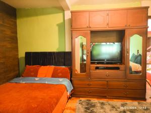 sypialnia z dużym drewnianym centrum rozrywki z telewizorem w obiekcie Casas vacacionales Baños w Baños