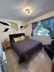 - une chambre avec un grand lit et une fenêtre dans l'établissement Departamento céntrico en Bariloche, à San Carlos de Bariloche