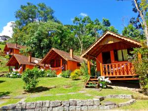 uma casa com um jardim em frente em pousada no caminho do escorrega em Visconde de Mauá