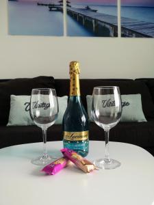 Apartamento OCEAN PEARL في كوراليخو: زجاجة من النبيذ وكأسين من النبيذ على الطاولة