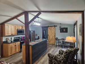 cocina y sala de estar con mesa y sillas en Grey Pines at Hocking Vacations, en Logan