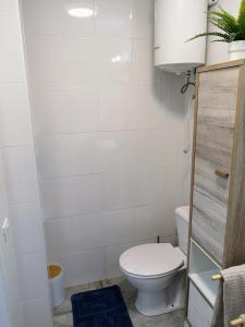 uma pequena casa de banho com um WC e um tapete azul em Apartamento OCEAN PEARL em Corralejo